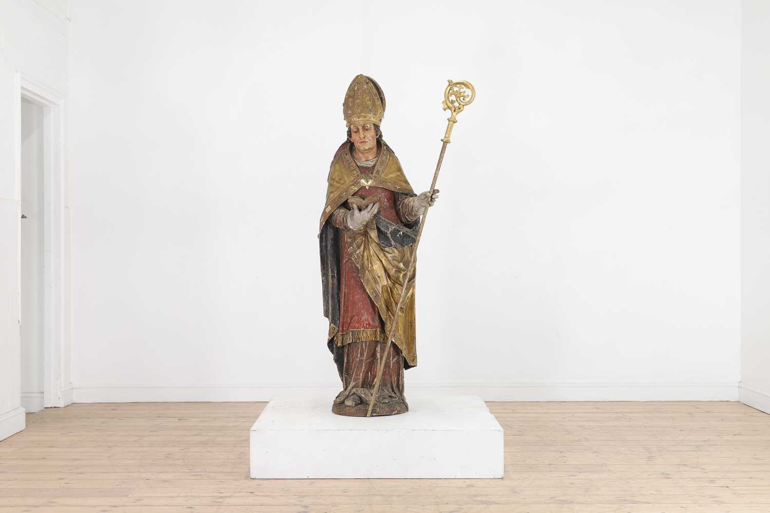 A carved and polychrome-painted pine figure of a saint