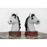 A pair of painted composite stone horse heads,
