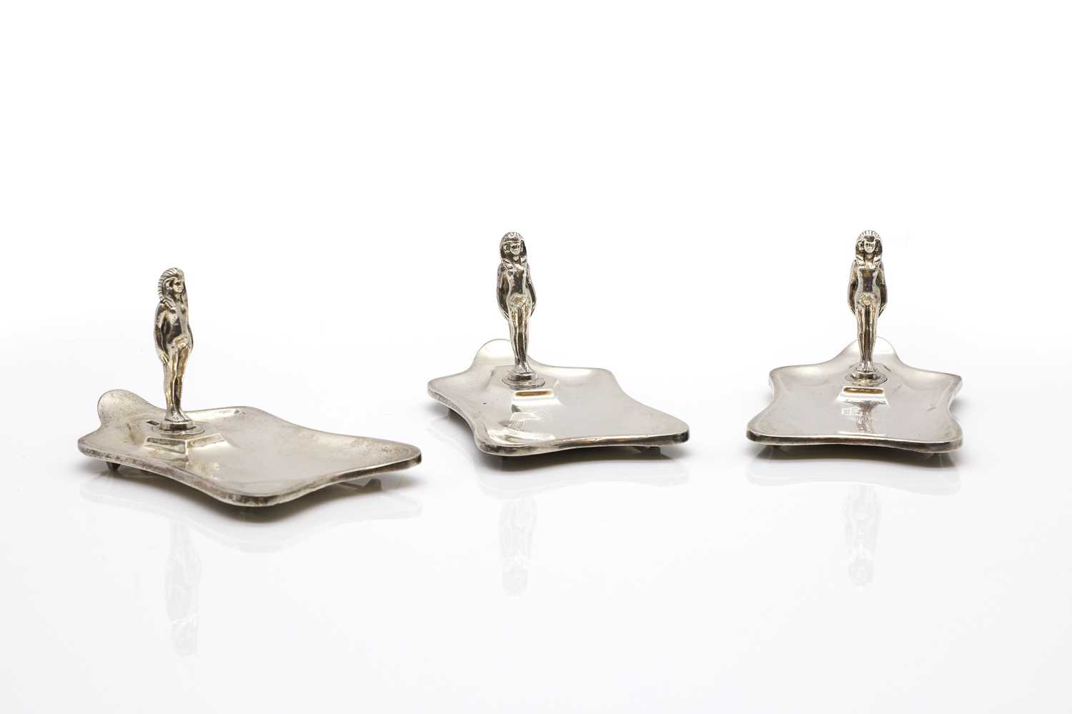 A set of three silver ashtrays
