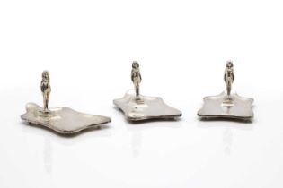 A set of three silver ashtrays