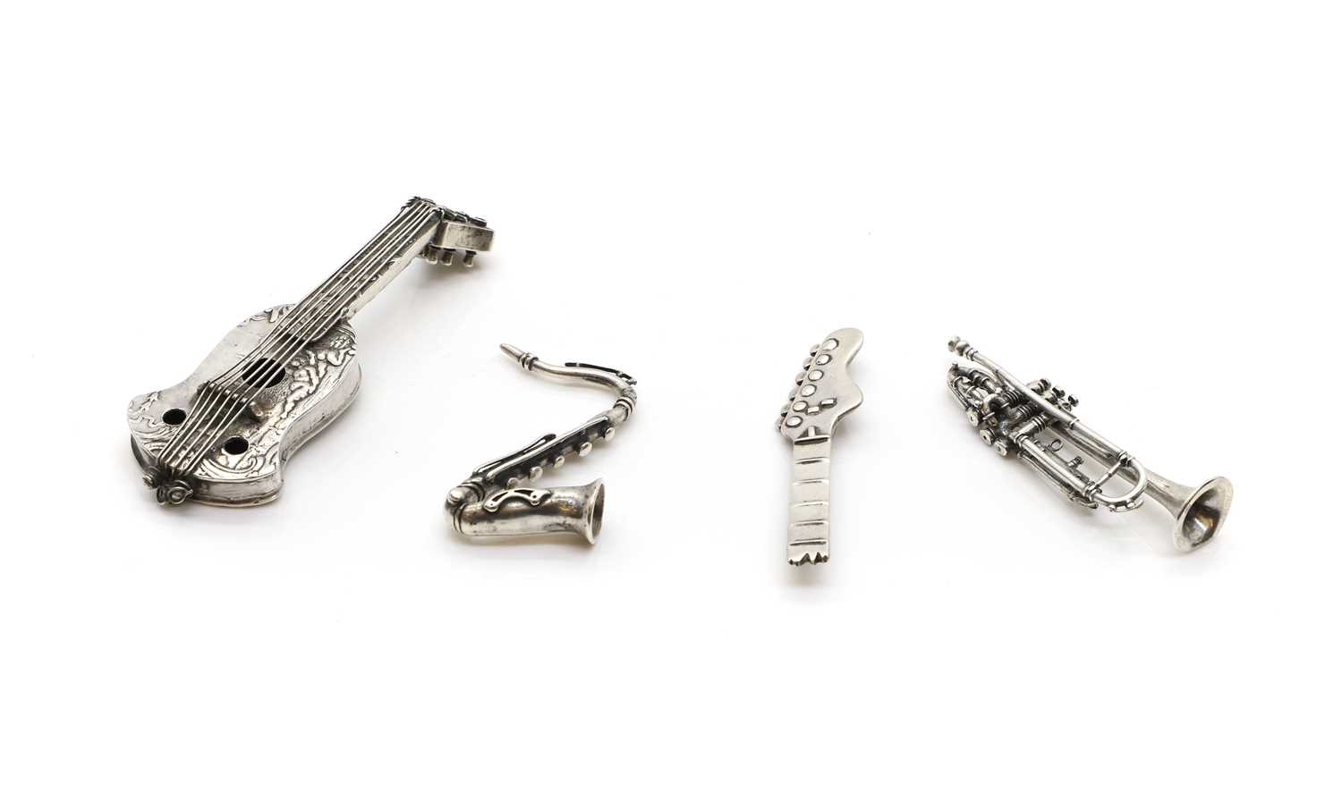 A group of four silver novelty musical instruments