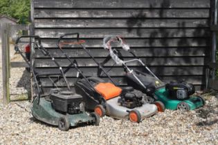 A group of three petrol lawnmowers