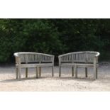 A pair of curved teak garden benches,