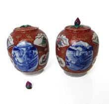 A pair of Japanese porcelain covered ginger jars, damage to lid of one jar