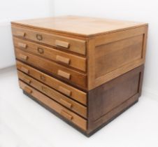 A mid-century light oak two-part plan chest - the cleated top over six long drawers with oak bar-