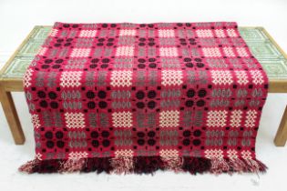 A woven woollen Welsh blanket - two ends fringed, with black, white and grey geometric motifs on a