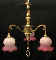 A three light brass and glass ceiling light - with three scroll arms issuing from a baluster and
