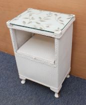 A Lloyd Loom style bedside cabinet - with floral silk embroidered fabric beneath the glass top,