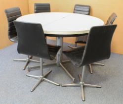 A retro 1960s-70s circular extending dining table and chairs - the white formica table with black