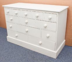 An off-white-painted pine chest of drawers - with an arrangement of thirteen short and long