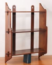 A 1920s oak wall hanging waterfall bookshelf - the shallow upper and two deeper lower shelves with