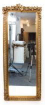 A giltwood and resin framed long mirror - the bevelled rectangular plate within a guilloche