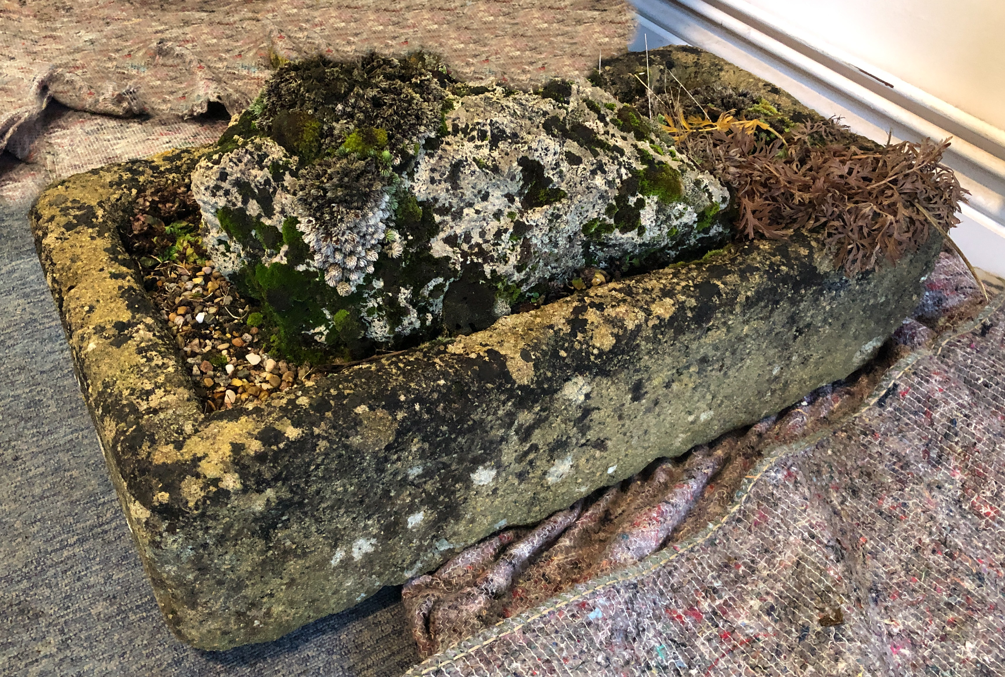 A composite stone garden trough - well weathered, with rock feature and planted with alpines. (LWH