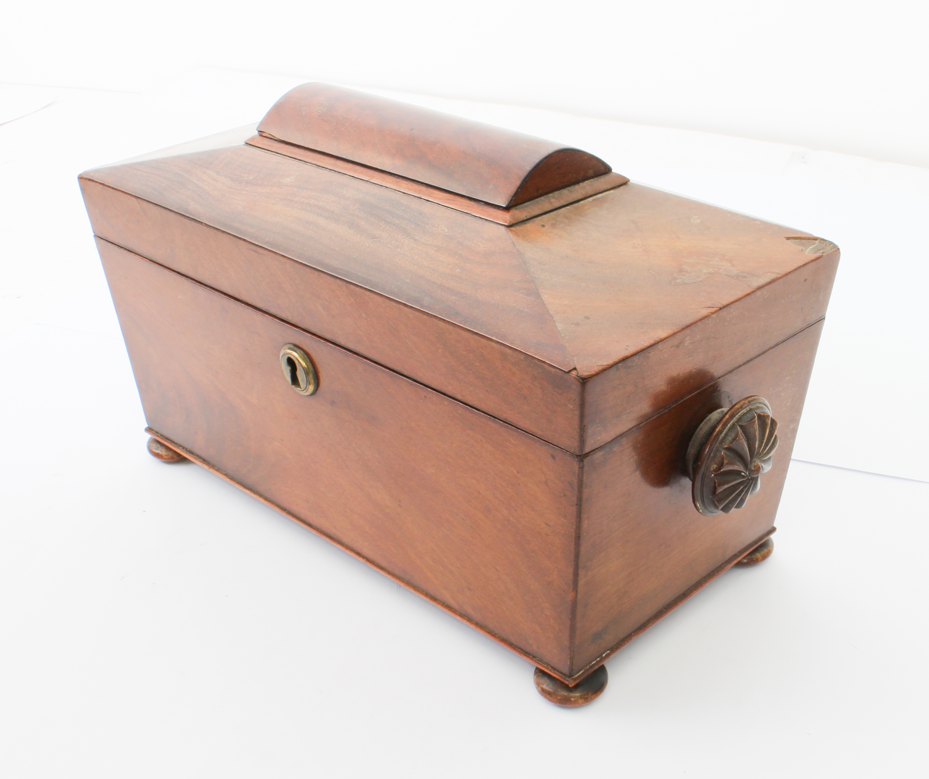 A mid-19th century mahogany sarcophagus tea caddy - with fan carved handles and turned bun feet, the