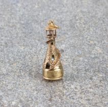 A 9ct gold lighthouse bracelet charm - hallmarked London 1984, 3.2 cm high plus suspension ring,