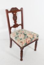 An Edwardian carved walnut nursing chair - the serpentine top rail and pierced vase splat carved