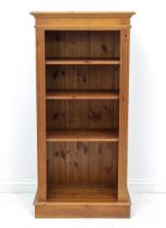 A pine three shelf open bookcase - with adjustable shelves and fluted stiles, on a plinth base. (LWH