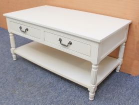 An off-white painted two-tier coffee table - the bevelled rectangular top over two frieze drawers