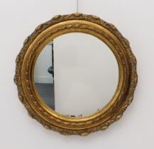 A small circular gilt and composition mirror in the 19th century style - with slightly shaped