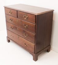A George III oak straight-front chest - the moulded top over two short and three long graduated