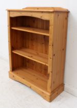 A pine open bookcase - with short upstand over three open shelves, on an arched plinth base. (LWH