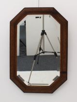 A 1930s octagonal carved oak mirror - the bevelled plate within a moulded frame, lightly carved with