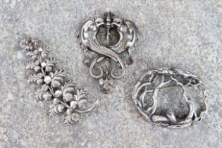 Two antique silver brooches - one oval, in the form of a stylised forest scene with entwined,