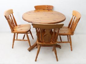 A circular pine kitchen table and four chairs - in 19th century style, the moulded top on a turned