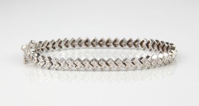 An 18ct white gold and diamond bracelet - stamped '750', the stepped, chevron shaped links each