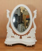 A Victorian-style off-white painted toilet mirror - the oval bevelled plate on foliate scroll carved