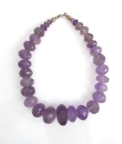 A vintage amethyst bead necklace - the facet cut beads graduating from 7mm. to 28mm diameter, with