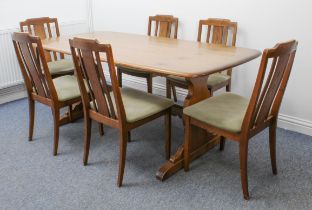An Ercol Windsor elm dining table - the slightly rounded rectangular top on shaped trestle end-