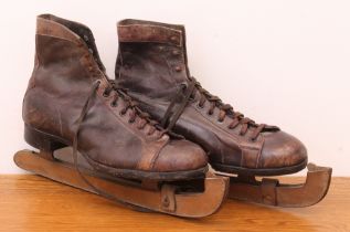 A pair of vintage brown leather ice skates - early 20th century, the boots with eight eyelets and