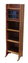 An Edwardian satinwood and mahogany narrow part-glazed bookcase - the open shelf top over a leaded