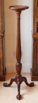 An Edwardian carved mahogany torchere - the dished circular top on an octagonal elongated baluster