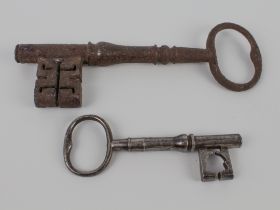 A large polished iron key (12.5 cm) and another larger unpolished example (20.5 cm)