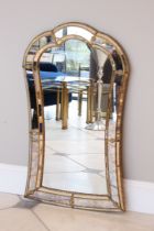 A Venetian-style mirror - modern, of cartouche form, with distressed mirrored and mirror-mosaic