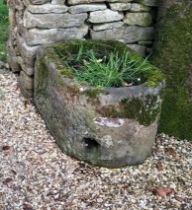 A carved limestone D-shaped garden trough