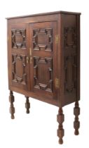 A 19th century panelled oak cabinet on stand - the chamfered top over a pair of geometric mitre