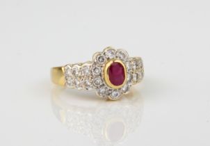 An 18ct yellow gold, ruby and diamond cluster ring - stamped '750', the central 5 x 3.5mm oval cut