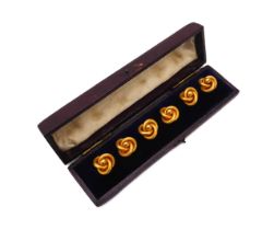 A cased set six Edwardian 9ct gold shirt studs - of knot form, in brushed gold, each stud 12mm wide,