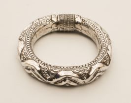 An Indian silver dancer's rattling armband or bangle, 11 cm in diameter, (107 g)