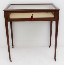 An Edwardian mahogany and satinwood-crossbanded vitrine table - the hinged glazed top over glazed