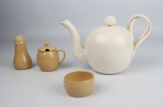 A reproduction Wedgwood creamware teapot and a Wedgwood buff-glazed three-piece cruet set