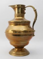 A large Edwardian brass ewer in Arts & Crafts style - the girdled, bun-shaped body on a pedestal