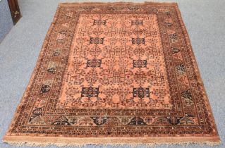 An Afghan hand knotted wool rug - second half 20th century, the pale madder field with two rows of