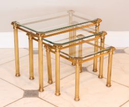 A nest of three antiqued brass and glass tables - late 20th century, the bevelled glass tops