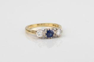 A fine 18ct gold three-stone ring, set with a well-coloured central sapphire (approx. .30 ct) and