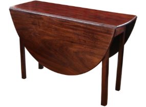 A George III mahogany oval dropflap dining table - with good colour, opening on a gateleg, raised on