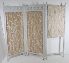 An off-white painted wooden three-fold screen - with tulip pierced panels and turned finials over